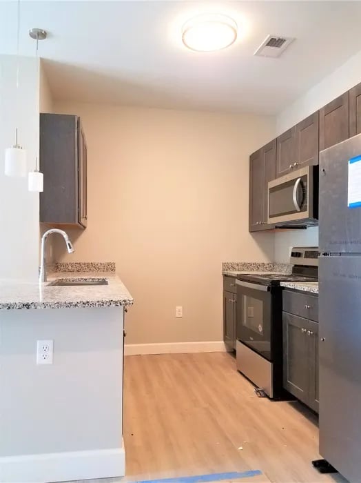 Modern kitchen with gray cabinets and stainless steel appliances Kitchen at Peak of Boone in Boone Student Accommodation