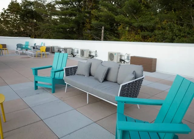 Sofa chairs and tables on outdoor patio exterior at Peak of Boone in Boone Student Accommodation