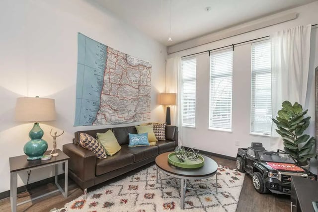 Brown leather sofa map wall windows living room at Arena District in Eugene Student Accommodation