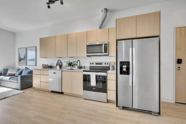 Modern kitchen with light wood cabinets refrigerator stove kitchen living area at Chapter at Eugene in Eugene Student Accommodation