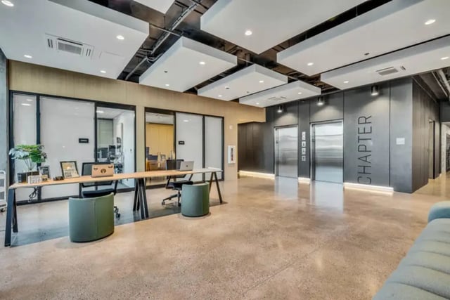 Long shared desk with laptops elevators and Chapter sign lobby at Chapter at Eugene in Eugene Student Accommodation