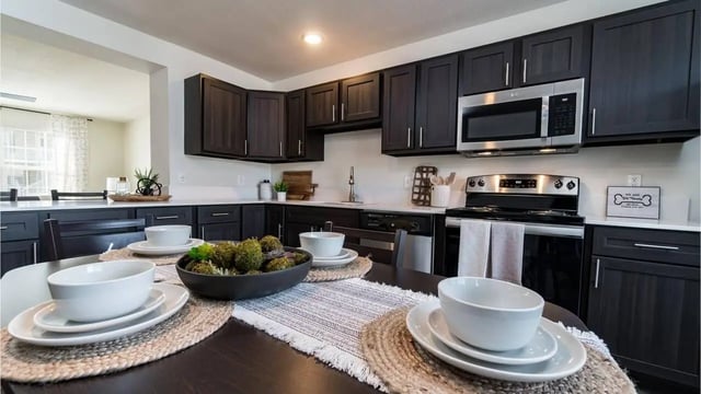 Dining table with place settings kitchen with dark cabinets kitchen at Copper Beech Townhomes - Harrisonburg in Harrisonburg Student Accommodation