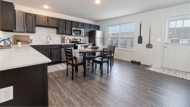 Dining table chairs cabinets appliances and kitchen area at Copper Beech Townhomes - Harrisonburg in Harrisonburg Student Accommodation