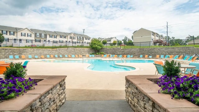 Resort style pool area with lounge chairs exterior at Copper Beech Townhomes - Harrisonburg in Harrisonburg Student Accommodation