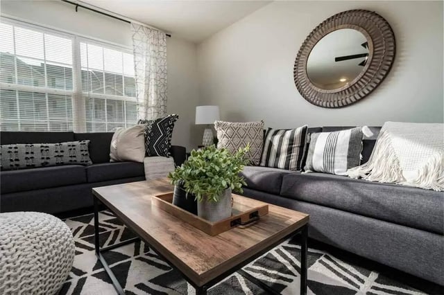 Dark sectional sofa wood coffee table living room at Copper Beech Townhomes - Harrisonburg in Harrisonburg Student Accommodation