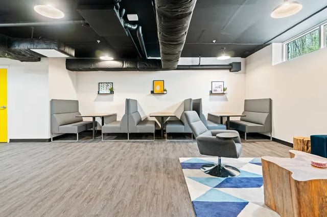 Gray booths chairs tables and rug lounge area at Rivers Walk in Boone Student Accommodation