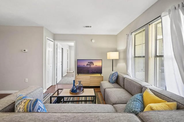 Gray sectional sofa TV and lamp living room at The Wilde Raleigh in Raleigh Student Accommodation