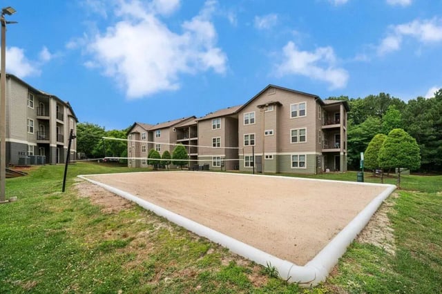 Apartment buildings with sand volleyball court exterior at The Wilde Raleigh in Raleigh Student Accommodation