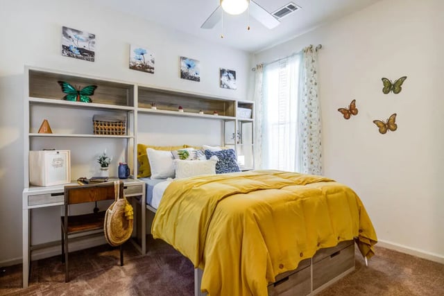 Bed with yellow comforter and desk Bedroom at Rush Charlotte in Charlotte Student Accommodation