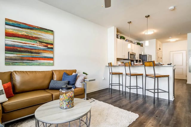 Brown sofa kitchen island barstools living room kitchen at Rush Charlotte in Charlotte Student Accommodation
