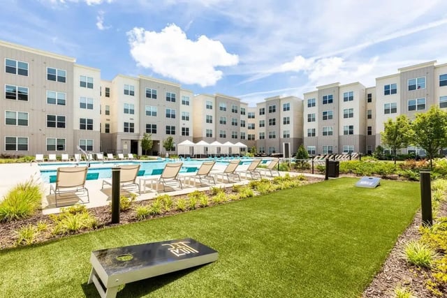 Apartment buildings pool lounge chairs cornhole exterior at Rush Charlotte in Charlotte Student Accommodation