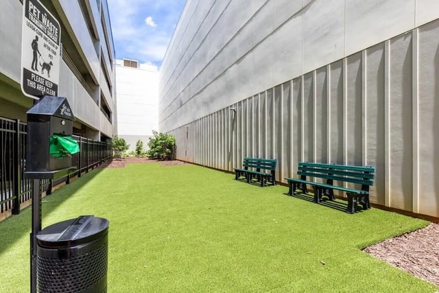 Pet waste station green benches on artificial turf dog area at Rush Charlotte in Charlotte Student Accommodation