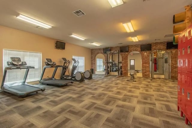 Gym with treadmills ellipticals weight racks and lockers. at Grove at Stephenville in Stephenville Student Accommodation