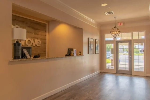 Reception desk with computer and chandelier lobby at Grove at Stephenville in Stephenville Student Accommodation