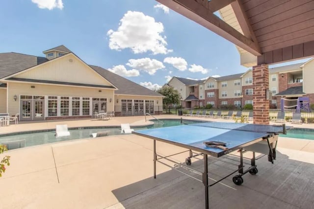 Ping pong table swimming pool and apartment buildings exterior at Grove at Stephenville in Stephenville Student Accommodation