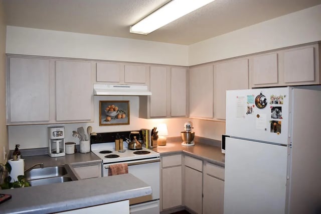 White cabinets refrigerator stove and sink kitchen at Table Rock in Flagstaff Student Accommodation