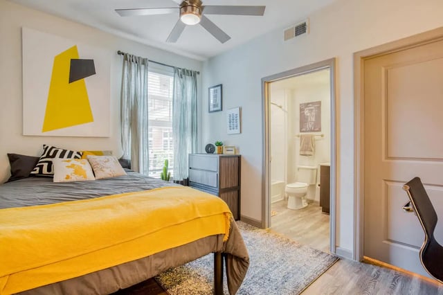 Bed with yellow blanket and adjoining bathroom Bedroom at Liv+ Arlington in Arlington Student Accommodation
