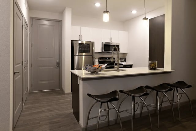 Stainless steel appliances island with bar stools kitchen at Liv+ Arlington in Arlington Student Accommodation