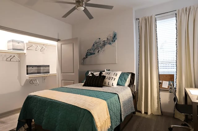Bed with pillows closet art and desk bedroom at Liv+ Arlington in Arlington Student Accommodation