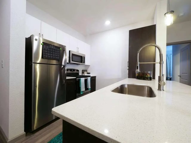 Stainless steel appliances white counters modern kitchen. at Liv+ Arlington in Arlington Student Accommodation