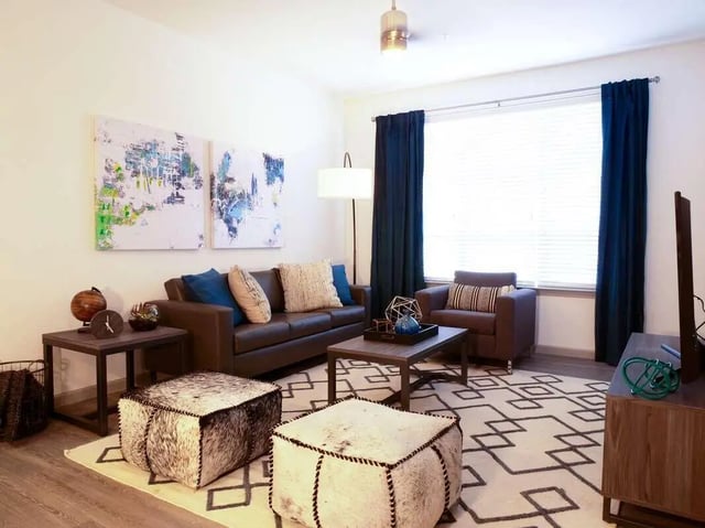 Leather sofa coffee table armchairs ottomans living room at Liv+ Arlington in Arlington Student Accommodation