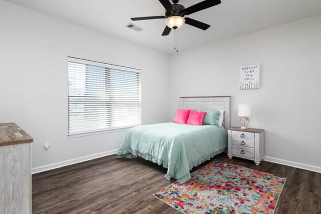 Bed with pink pillows ceiling fan nightstand bedroom at Traditions Oxford Apartments in Oxford Student Accommodation