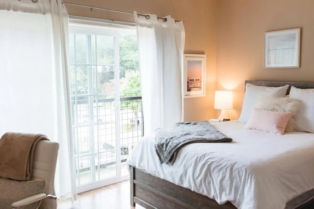 Bed with white linens grey throw lamp bedroom at Village Walk Oxford Apartments in Oxford Student Accommodation