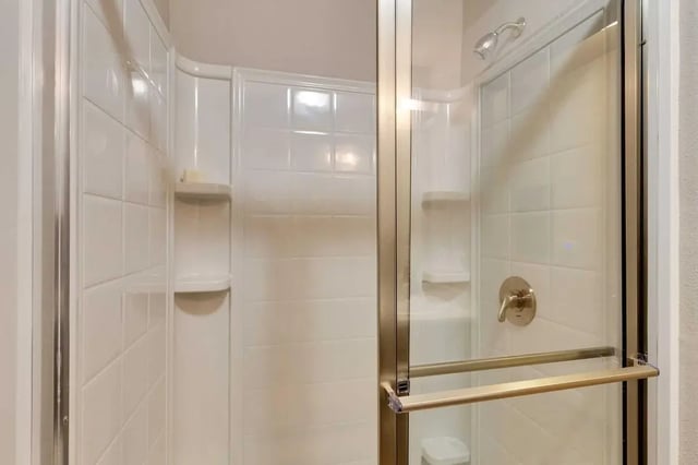 White tiled shower with shelves and glass door Bathroom at 12 North in College Station Student Accommodation