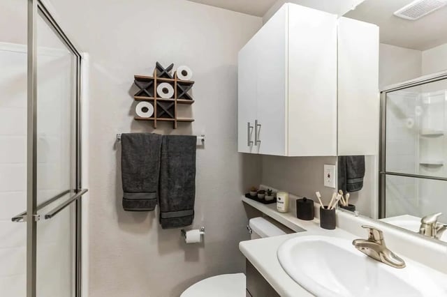 Shower sink cabinets towels tic tac toe bathroom at 12 North in College Station Student Accommodation