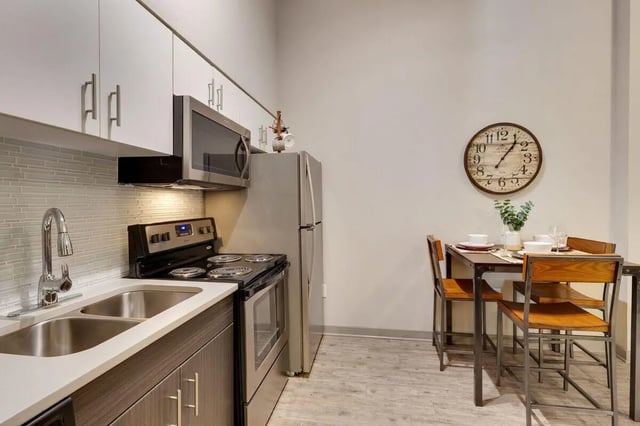 Kitchen with sink stove refrigerator and dining set Kitchen at 12 North in College Station Student Accommodation