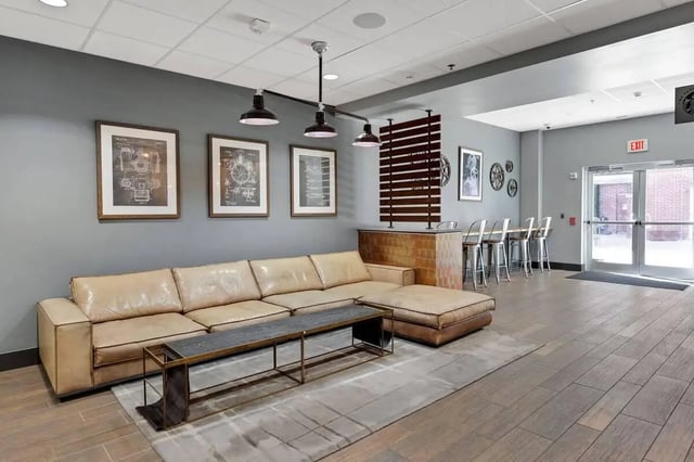 Large sectional sofa with coffee table and bar seating living room at 12 North in College Station Student Accommodation