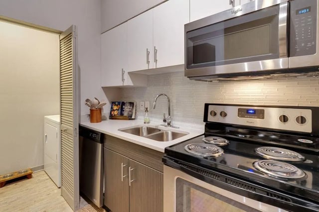 Cabinets sink stove microwave washer kitchen at 12 North in College Station Student Accommodation