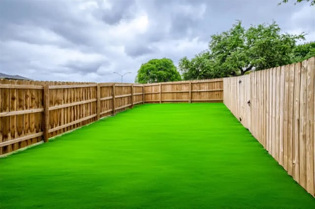 Backyard with green grass and wooden fence exterior at BelCara Luxury Townhomes in San Antonio Student Accommodation