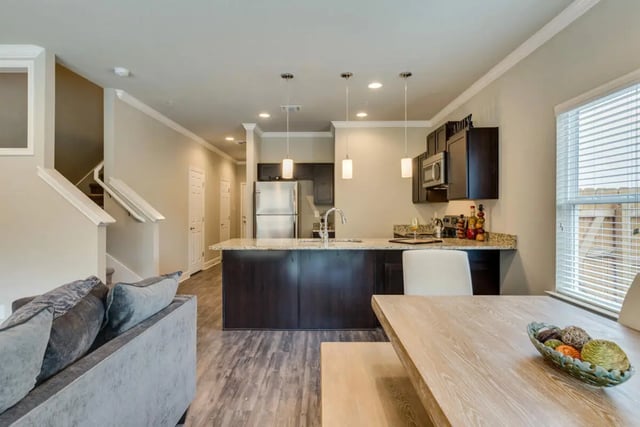 Sofa stairs kitchen island dining table living room at BelCara Luxury Townhomes in San Antonio Student Accommodation
