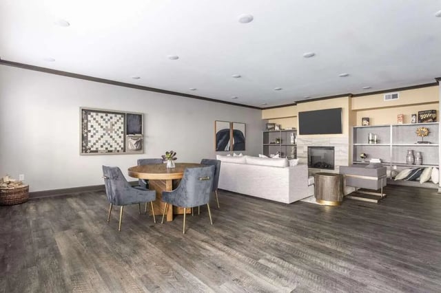 Round dining table grey chairs white sofa living room at Bridge at Cameron in Austin Student Accommodation