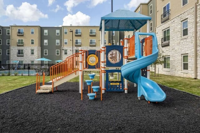 Blue slide orange stairs playground building exterior at Bridge at Cameron in Austin Student Accommodation