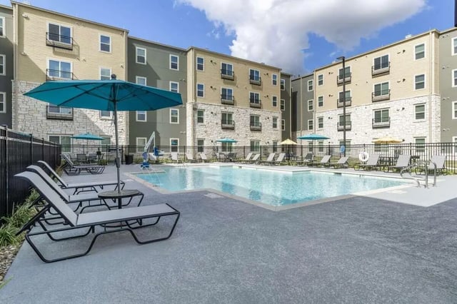 Pool with lounge chairs and buildings exterior at Bridge at Cameron in Austin Student Accommodation