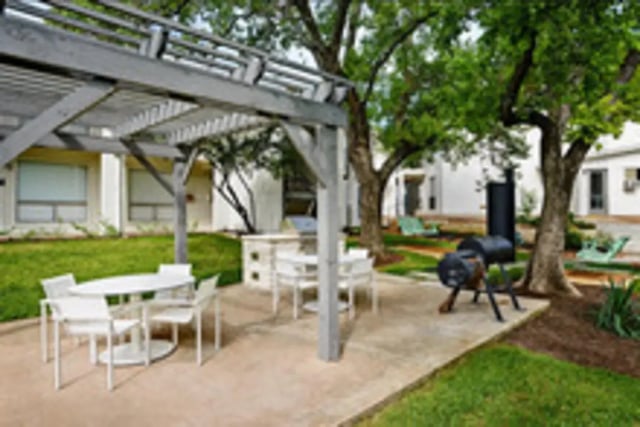 Outdoor patio with tables grill and seating area exterior at Establishment in Austin Student Accommodation