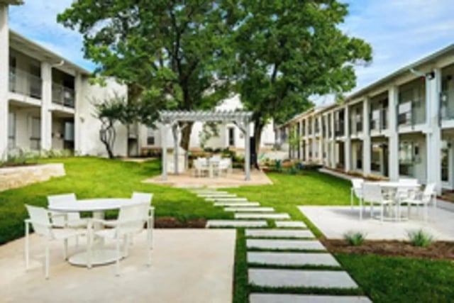 White tables chairs and outdoor living area exterior at Establishment in Austin Student Accommodation