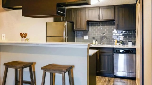 Kitchen with stainless steel appliances and bar stools kitchen at Establishment in Austin Student Accommodation