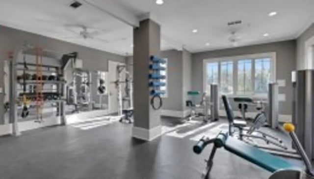 Weight machines and racks in a gym at The Cottages at Lake Tamaha in Tuscaloosa Student Accommodation