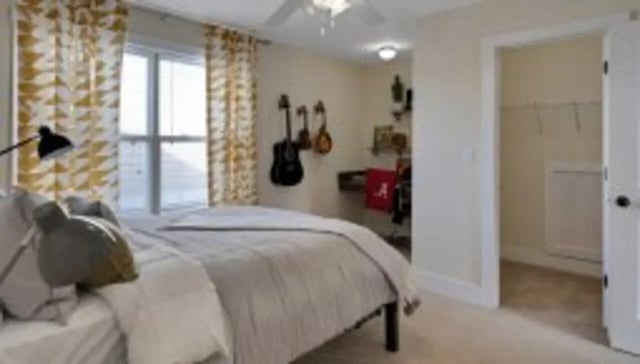 Bed with patterned curtains guitars and desk Bedroom at The Cottages at Lake Tamaha in Tuscaloosa Student Accommodation