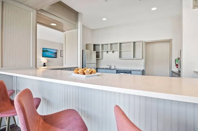 Muffins on counter with pink chairs kitchen at Central House on Stadium in Mobile Student Accommodation