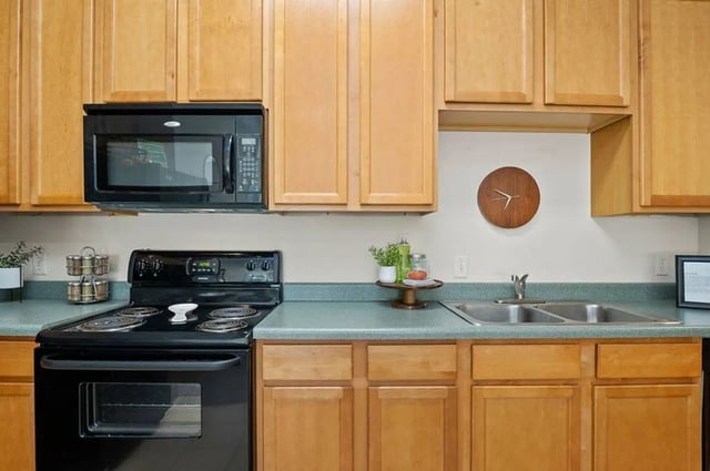 Black stove microwave wooden cabinets sink kitchen at Central House on Stadium in Mobile Student Accommodation