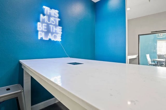 White table with neon sign study area at Central House on Stadium in Mobile Student Accommodation