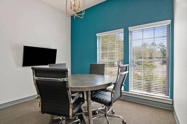 Round table four chairs wall mounted TV study area at Central House on Stadium in Mobile Student Accommodation