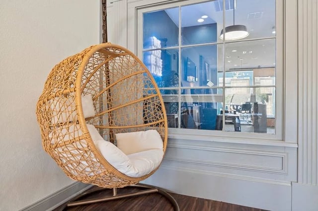 Wicker egg chair with cushions near window lounge area at Central House on Stadium in Mobile Student Accommodation