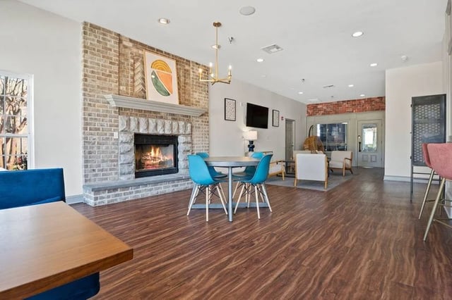 Living room with fireplace blue chairs and tables at Central House on Stadium in Mobile Student Accommodation
