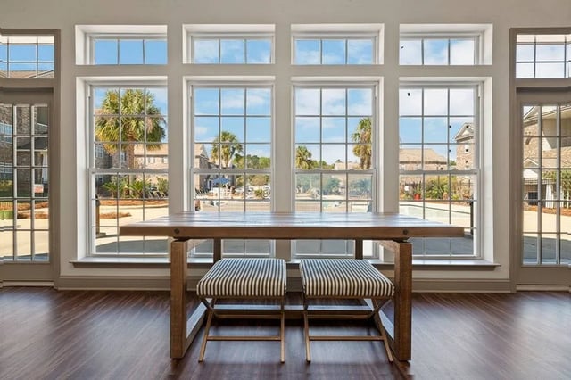 Wooden table two striped stools large windows interior at Central House on Stadium in Mobile Student Accommodation