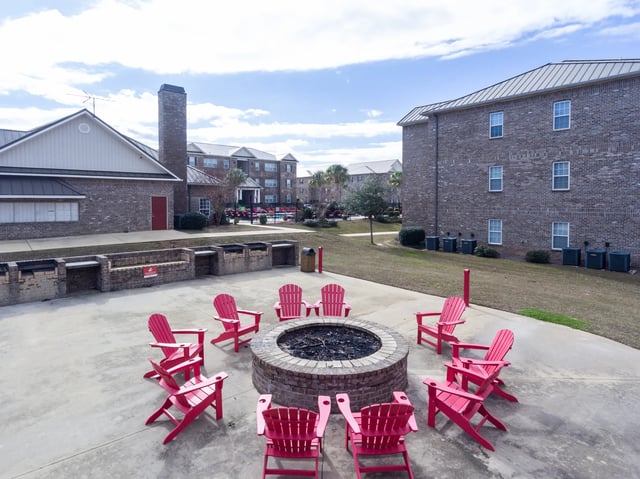 Fire pit and pink chairs outdoor common area at Central House on Stadium in Mobile Student Accommodation